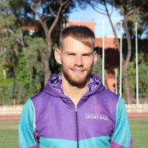 Atleta sorridente in tuta sportiva viola e verde acqua {{brizy_dc_image_alt imageSrc=